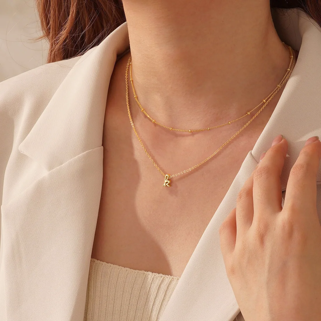Two gold chains layered on the collarbone